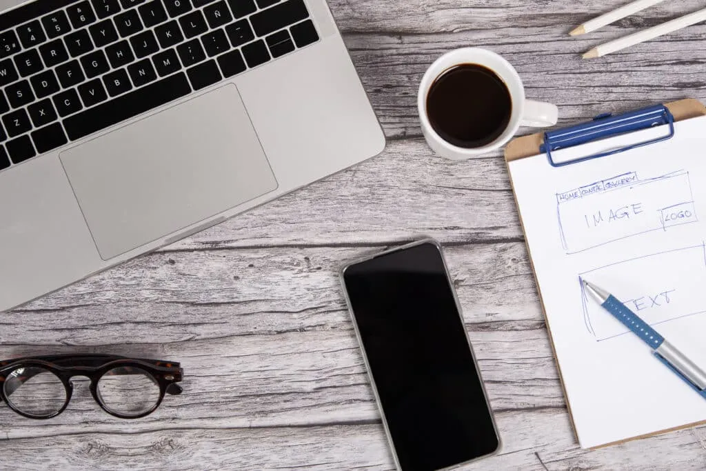 Website-Optimierung-website designer work table with laptop and a smart phone on a wooden desk
